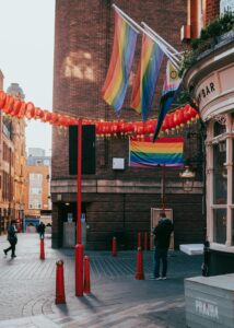 Colorful Chinatown street with red lanterns and rainbow flags, symbolizing diversity and culture in London.