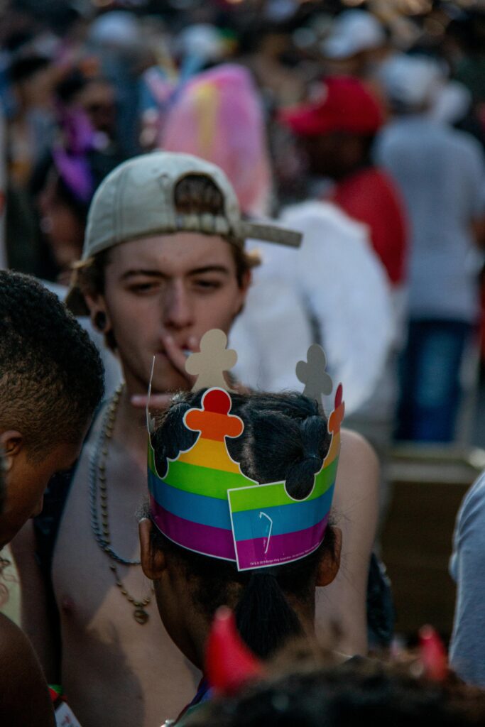 Close-up of colorful LGBT pride celebration with people wearing rainbow crowns in São Paulo, Brazil.